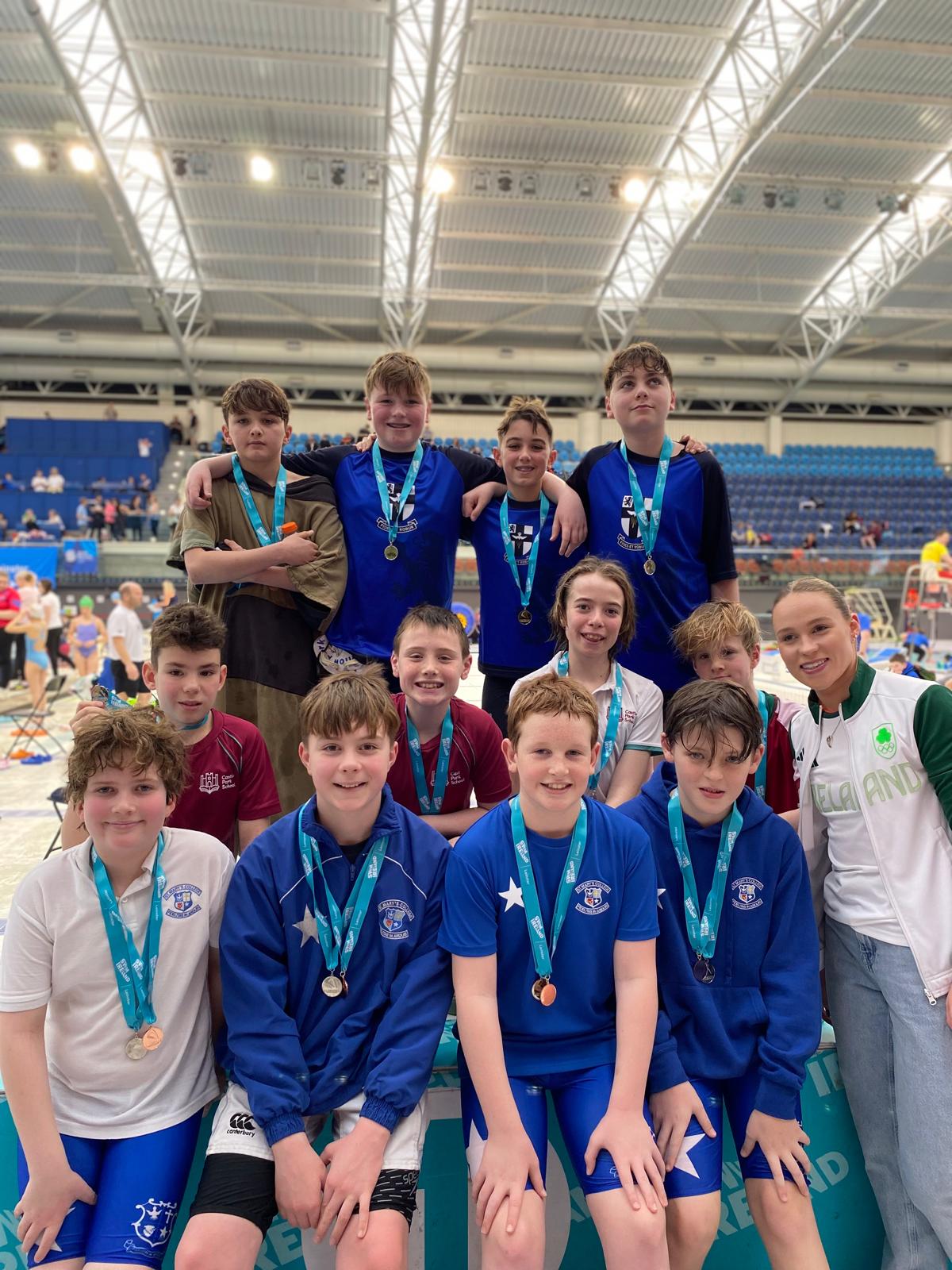 Group shot of swimmers with medals on a podium