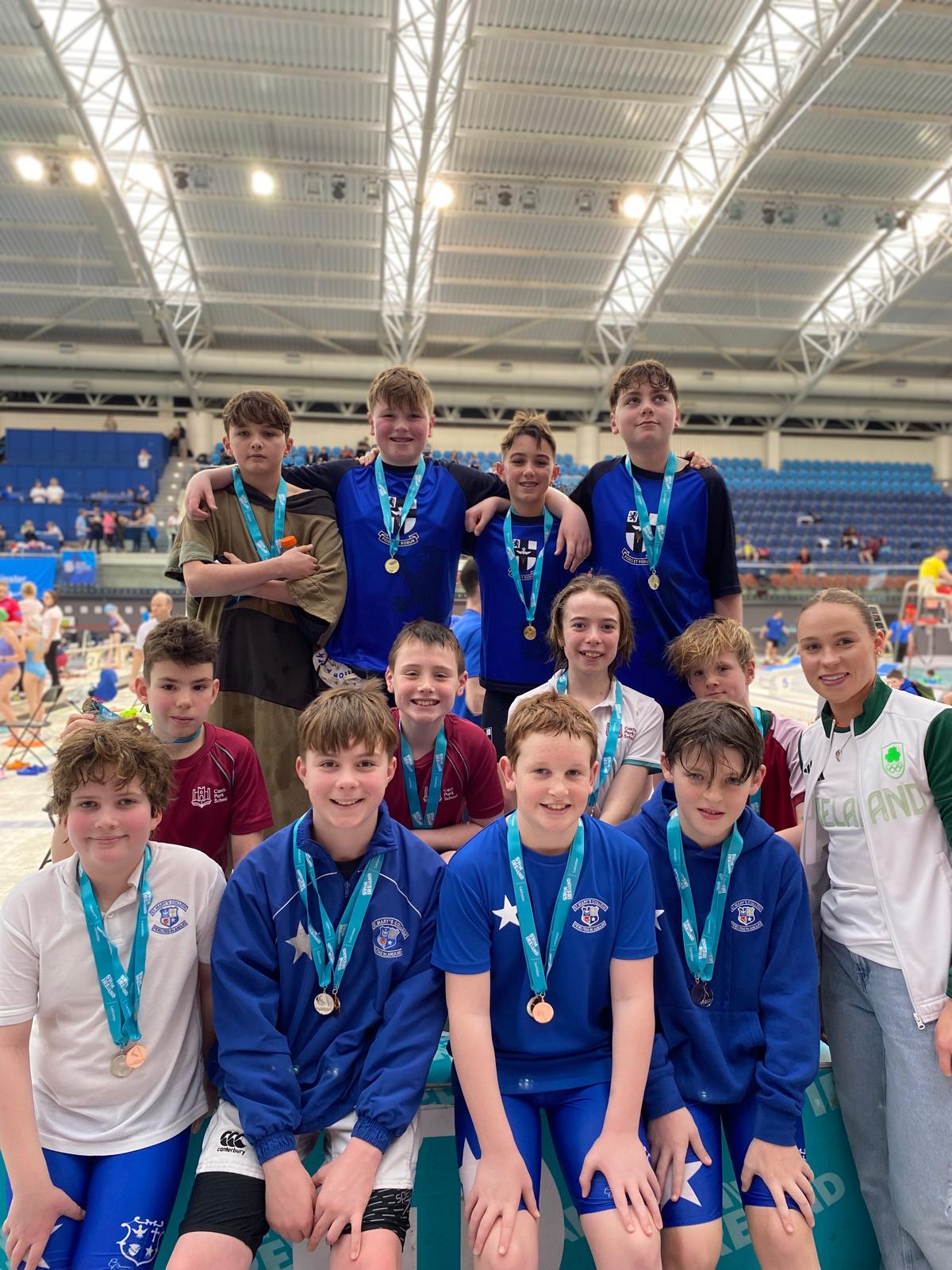 Group shot of swimmers with medals on a podium