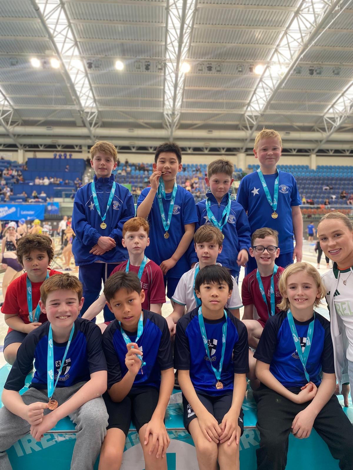 Group shot of swimmers with medals on a podium