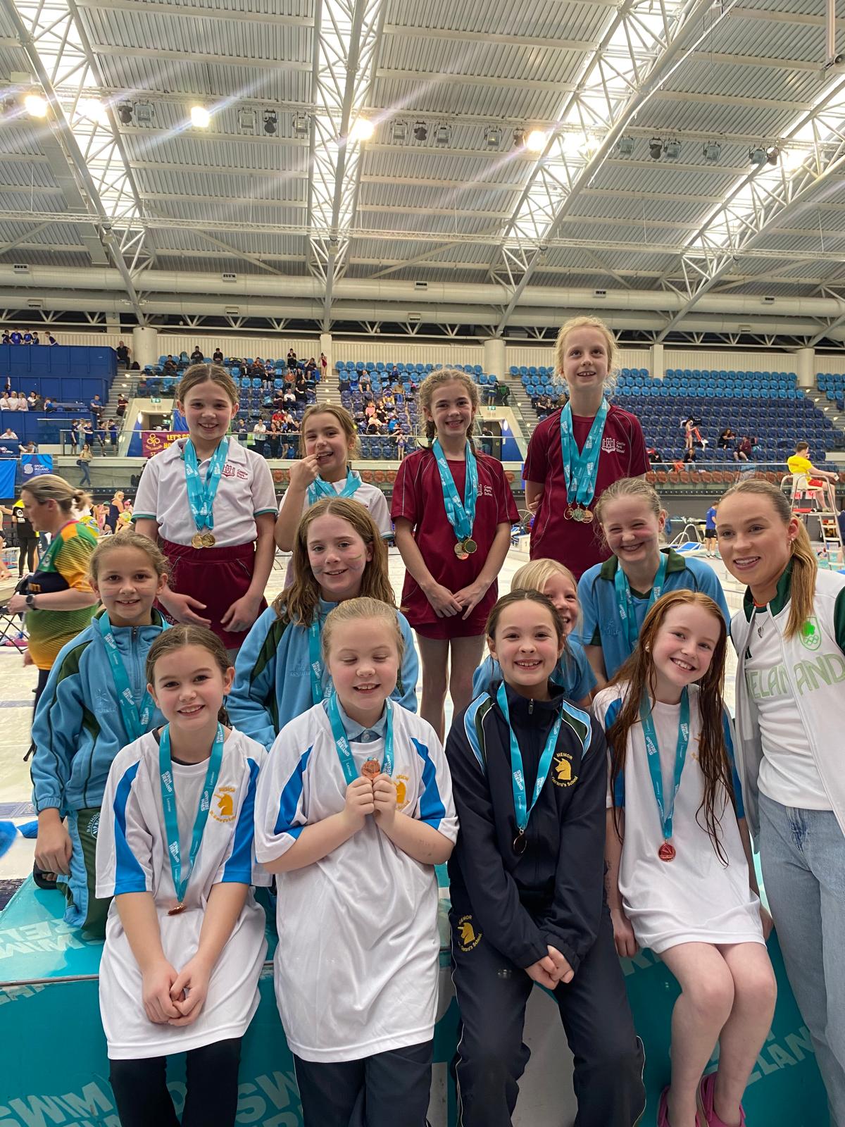 Group shot of swimmers with medals on a podium