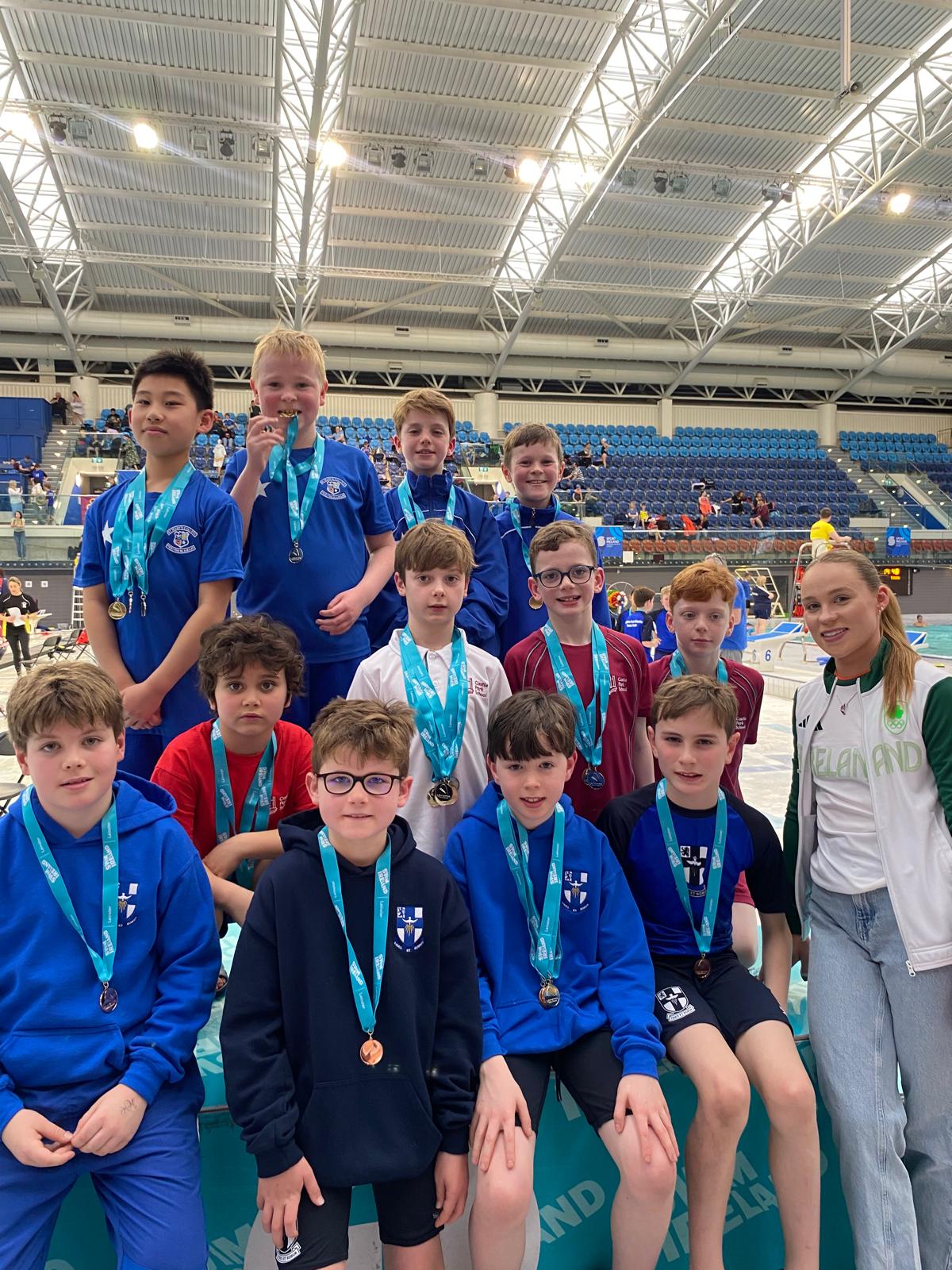 Group shot of swimmers with medals on a podium