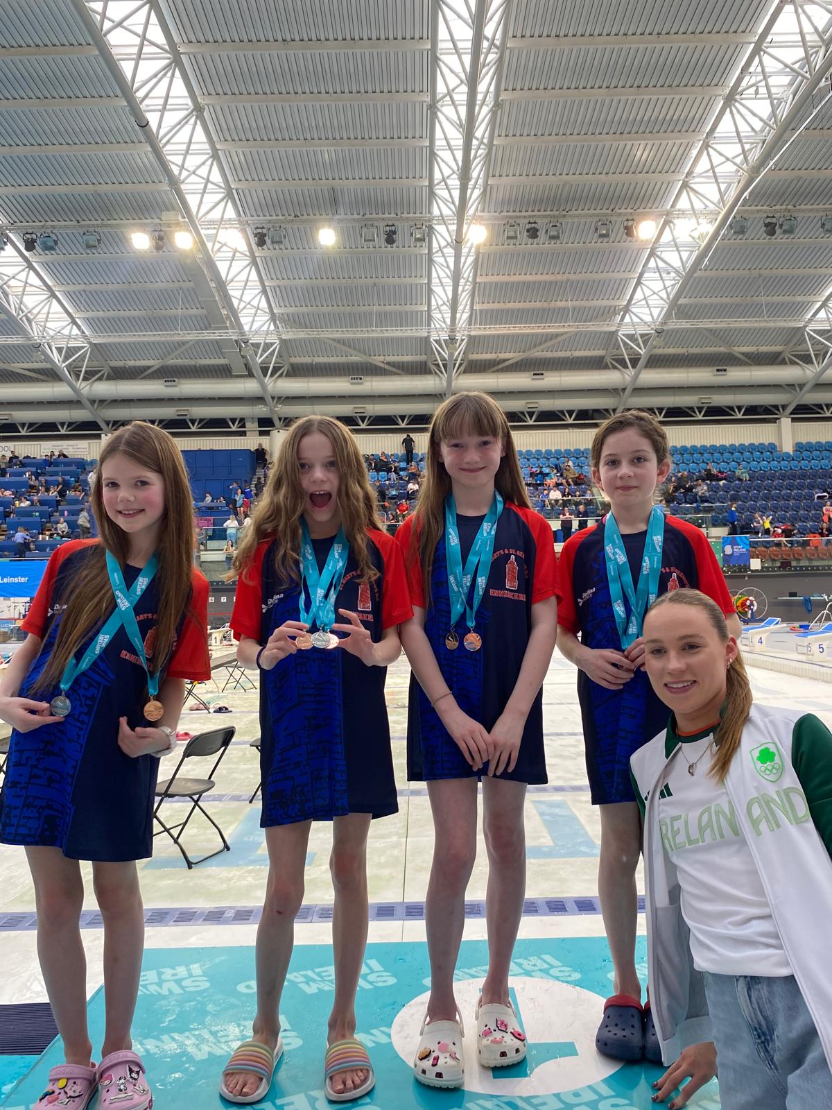 Group shot of swimmers with medals on a podium